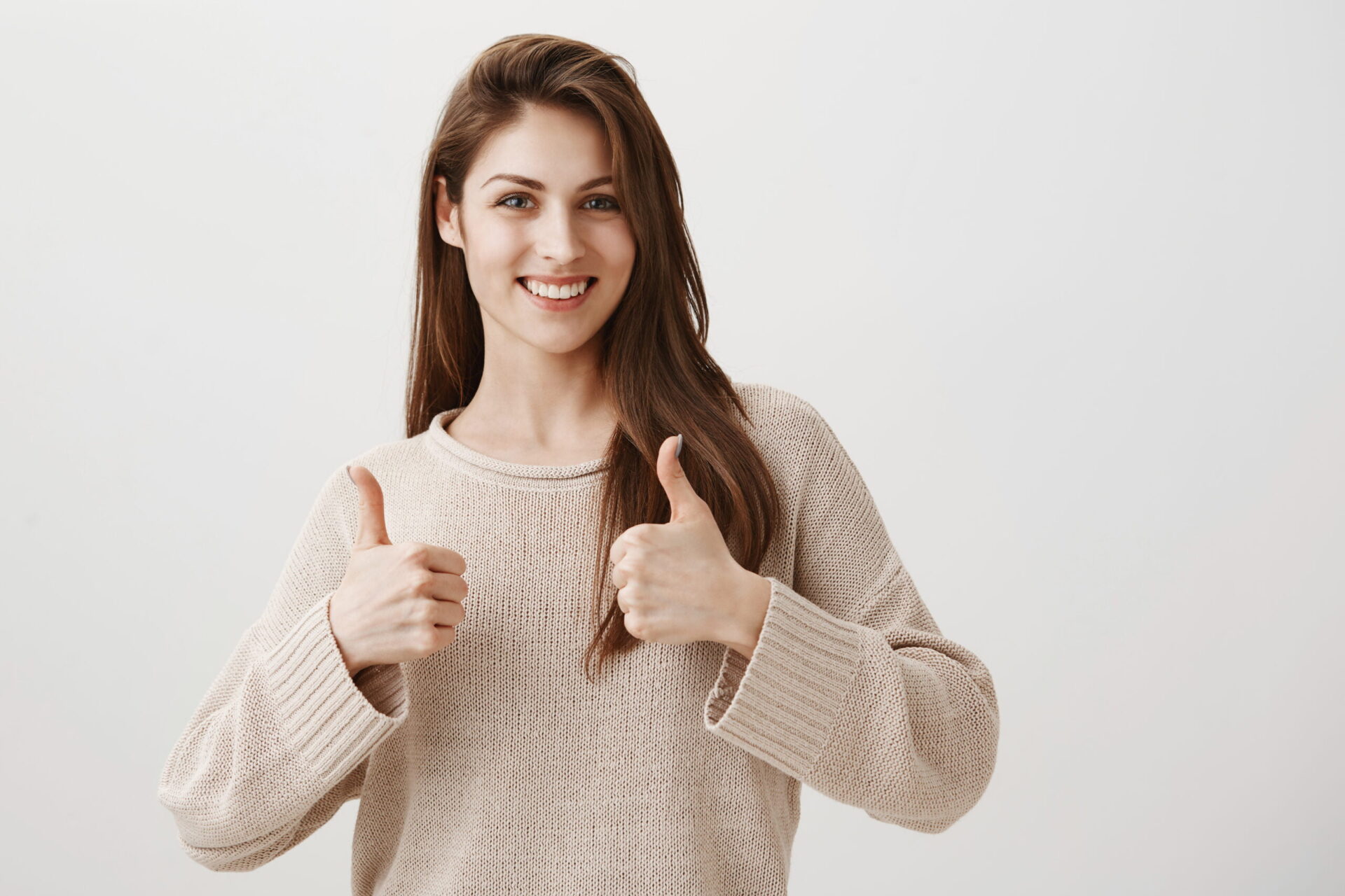 Smiling woman giving double thumbs up.